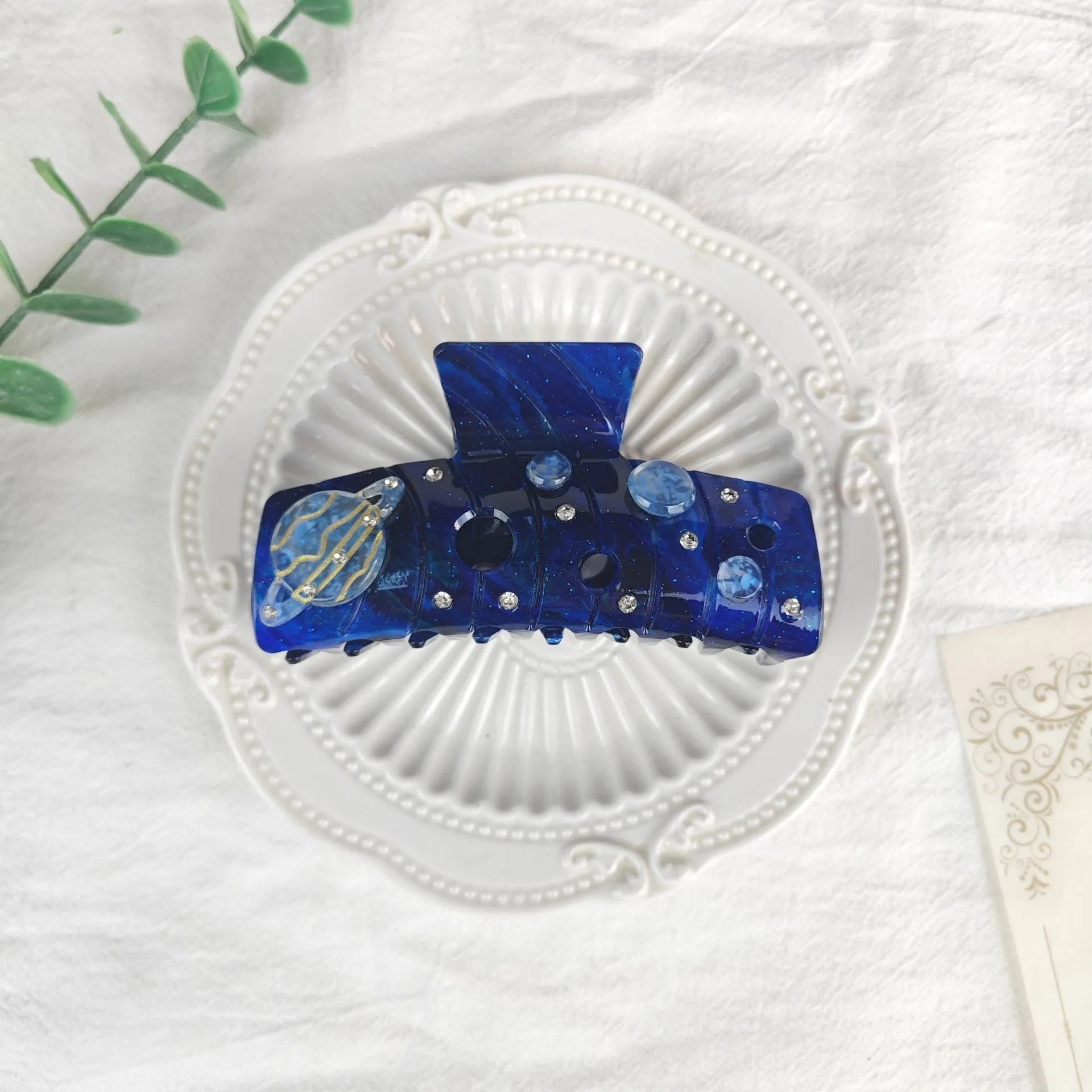 Oversized women's barrette with a starry sky design in blue, made from cellulose acetate sheet.