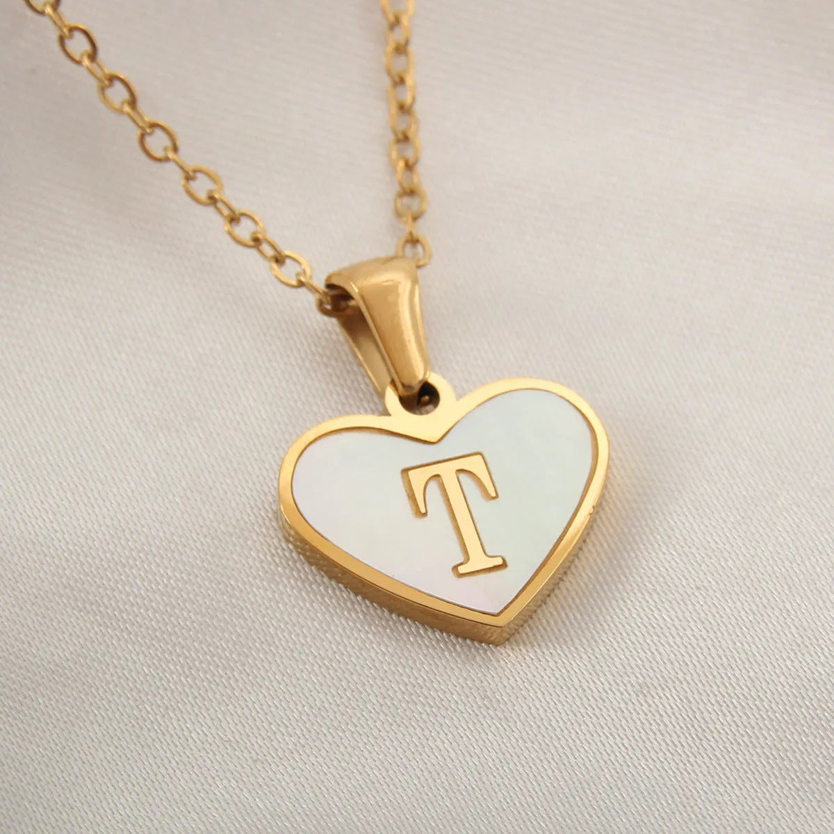Gold plated heart-shaped necklace with white shell pendant on adjustable stainless steel chain