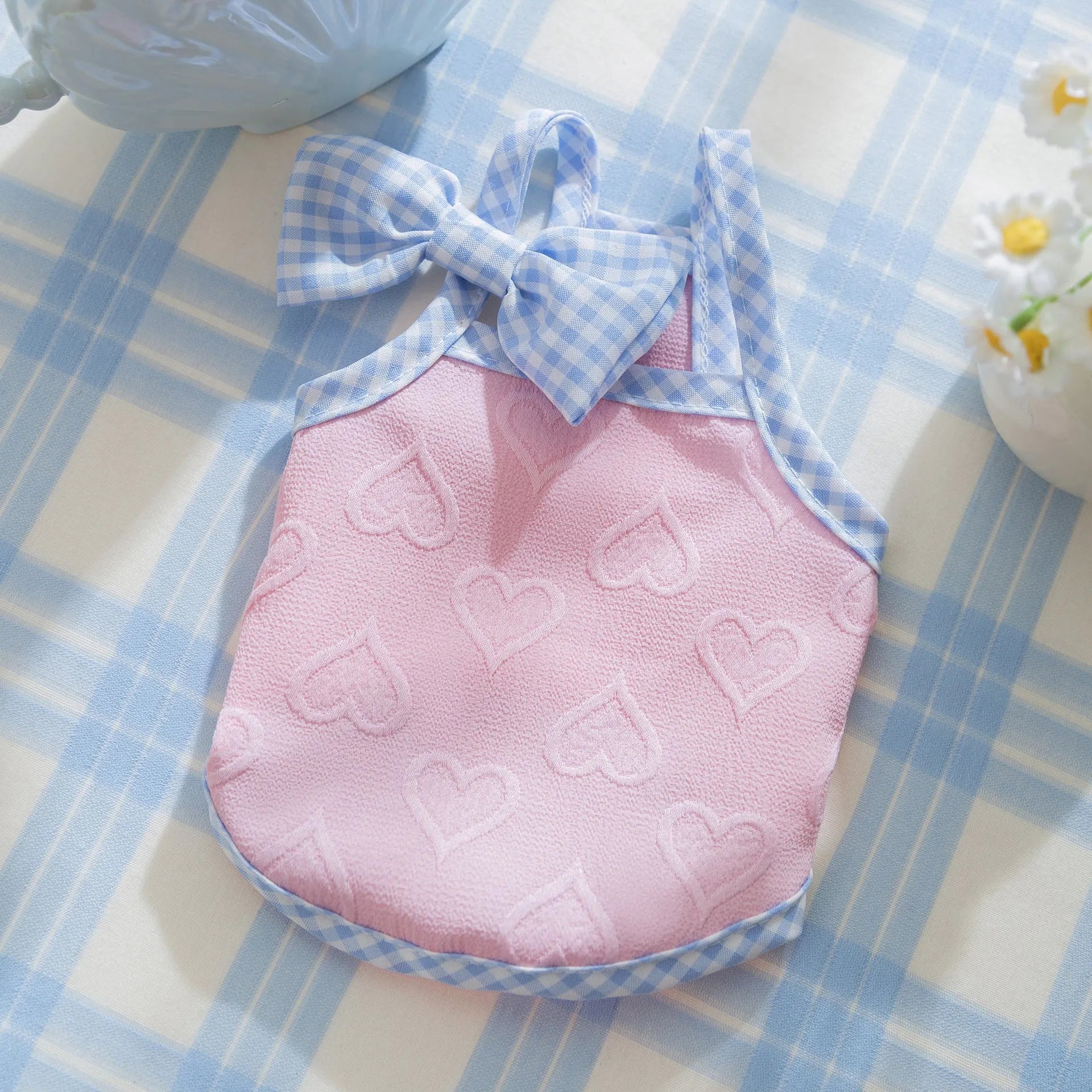 Small dog wearing heart bow suspenders vest in blue with elastic sides