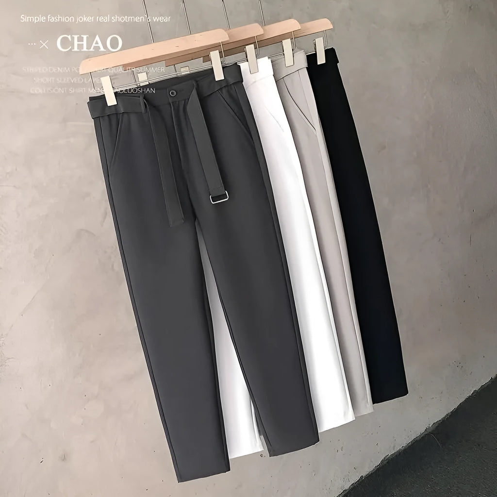 Boy wearing slim straight wool trousers in a neutral colour, showcasing the tapered fit and straight leg opening.