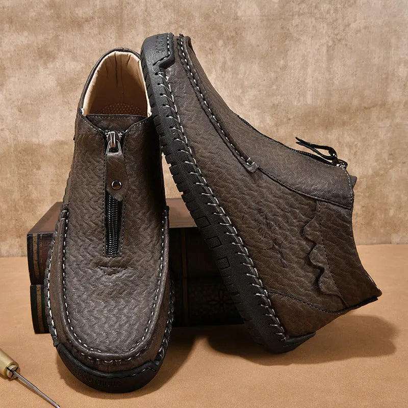 Men's black slip-on loafers with round toe and sewing thread detail on a rubber sole.