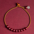 Hand-woven cinnabar geometric bracelet showing raw ore material texture and adjustable design