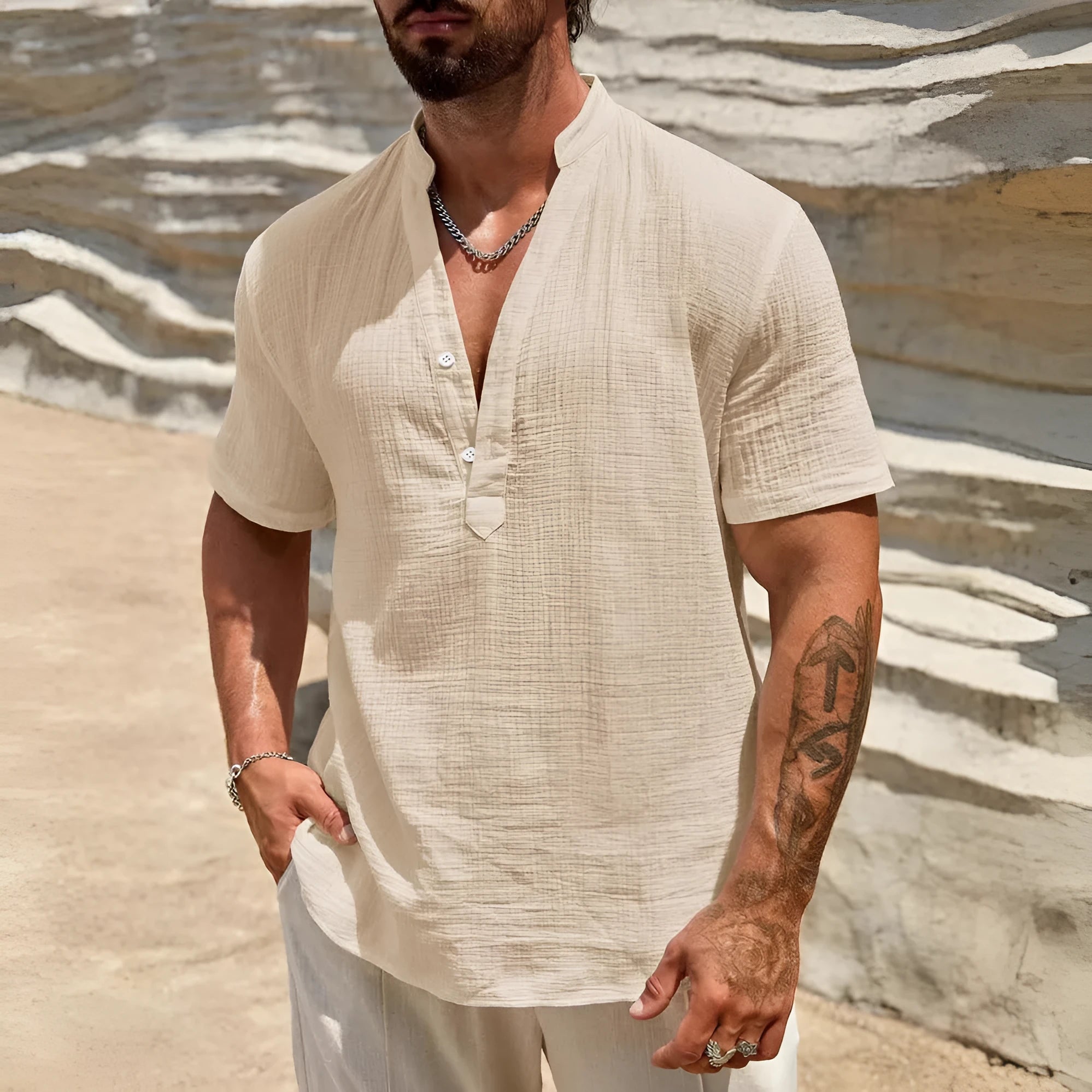 Man wearing a solid colour short-sleeve shirt with a stand collar in a casual setting.