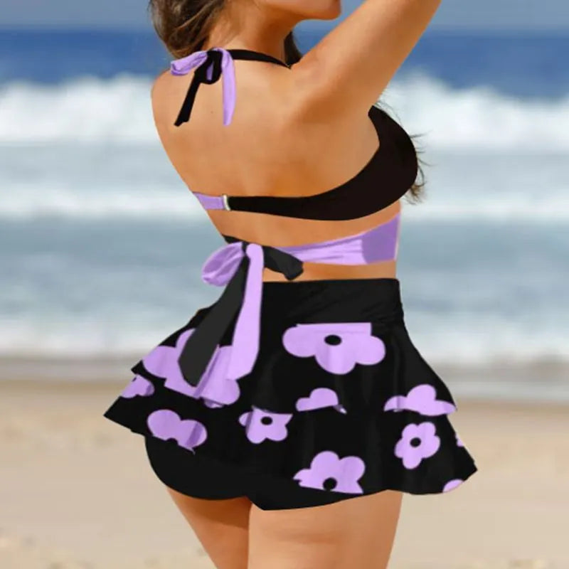 Women's purple split swimsuit bikini set with matching skirt and lace-up detailing