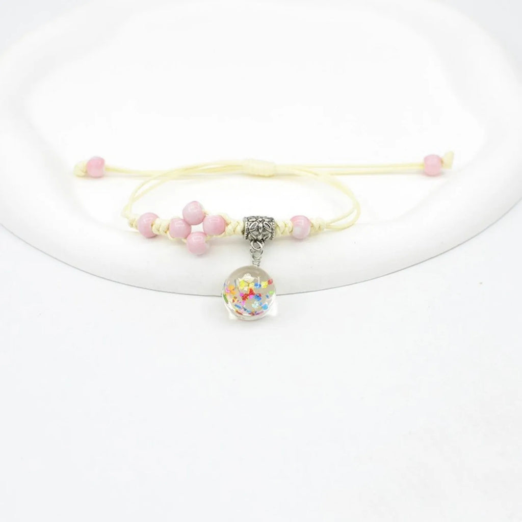 Close-up of a hand-woven glass bracelet with large 1.4 cm beads containing real dried flowers in multiple colour options.