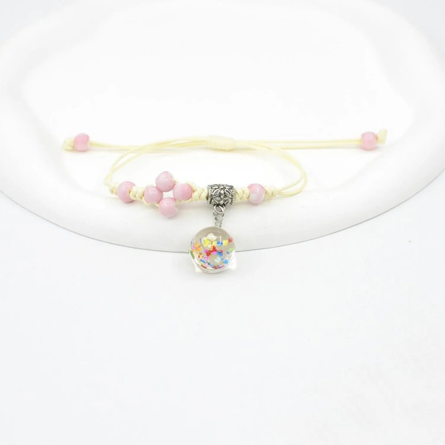 Close-up of a hand-woven glass bracelet with large 1.4 cm beads containing real dried flowers in multiple colour options.