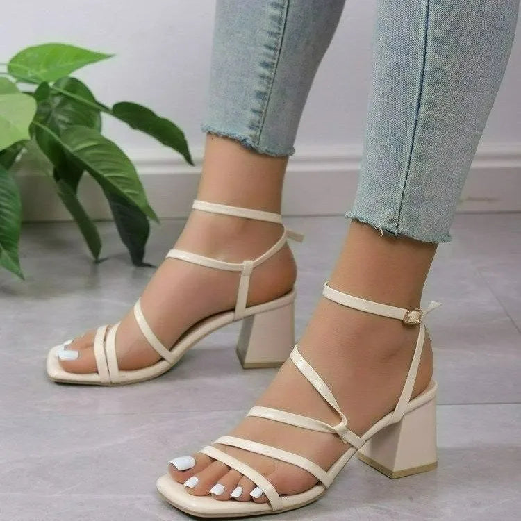 Plus size beige open toe slippers with a square toe and adjustable ankle buckle on a white background.