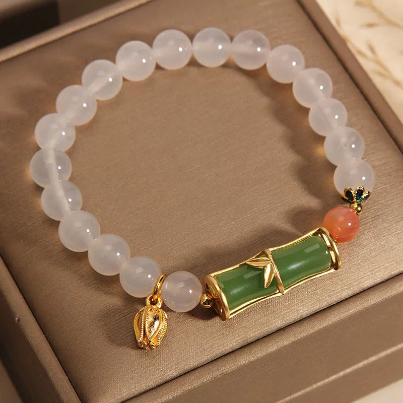 Close-up of a white agate jasper beaded bracelet with a jade bead in a Chinese bamboo style.