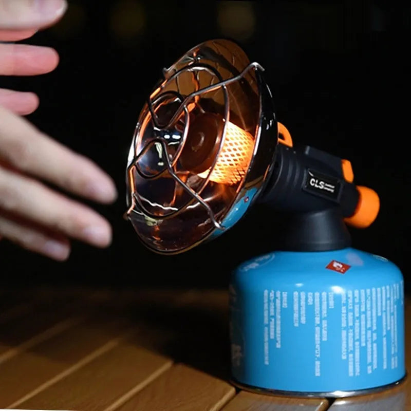 Black and orange portable camping heater stove with automatic ignition on a table.