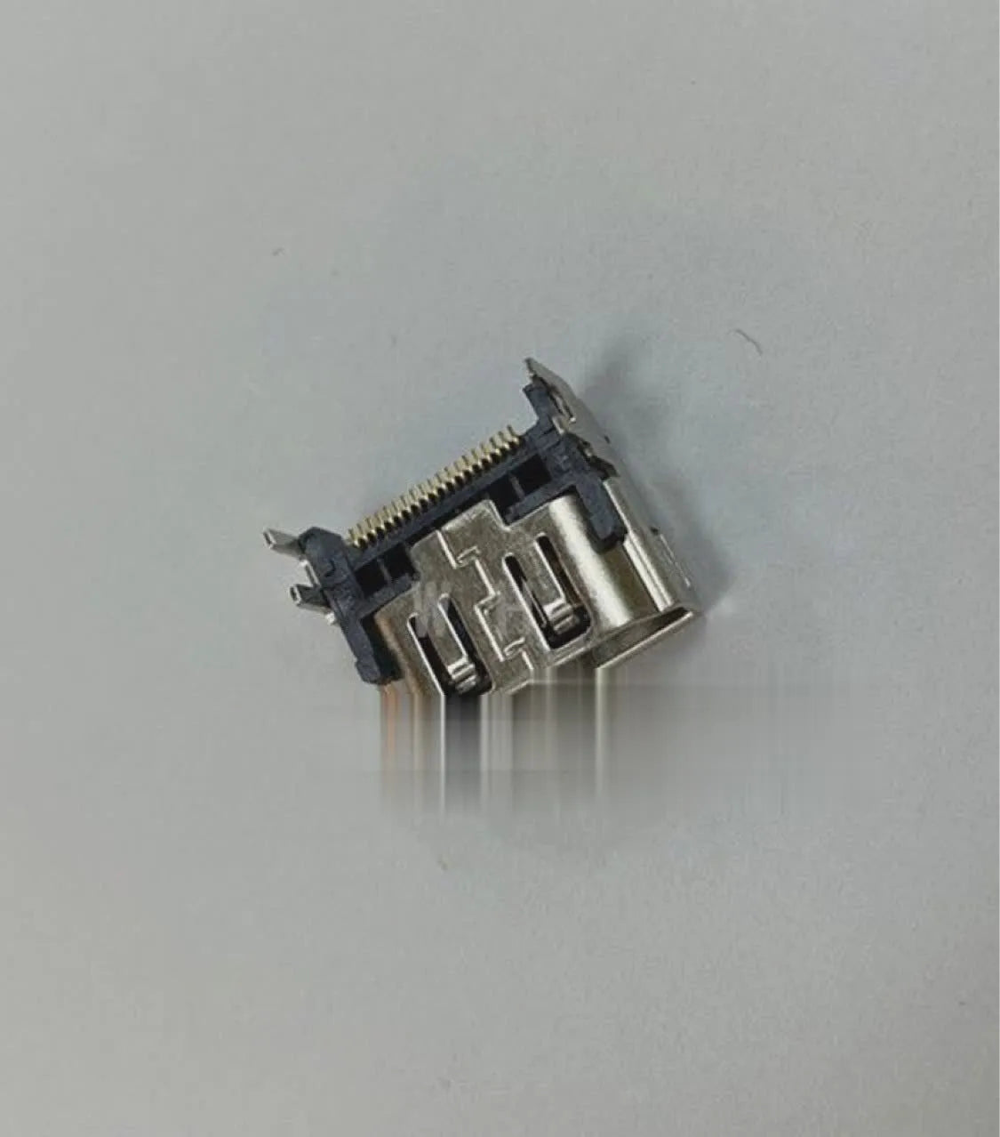 Silver-coloured HDMI host socket interface for game console repair.