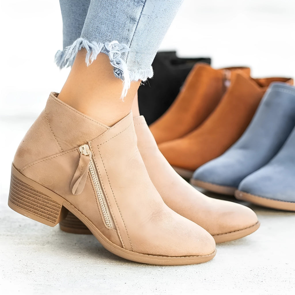 Women's beige suede chunky heel ankle boots with a side zip fastening, shown on a neutral background.