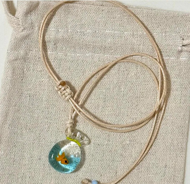 Women's necklace with Small Fish Lucky Bag glaze pendant on a cotton linen chain.