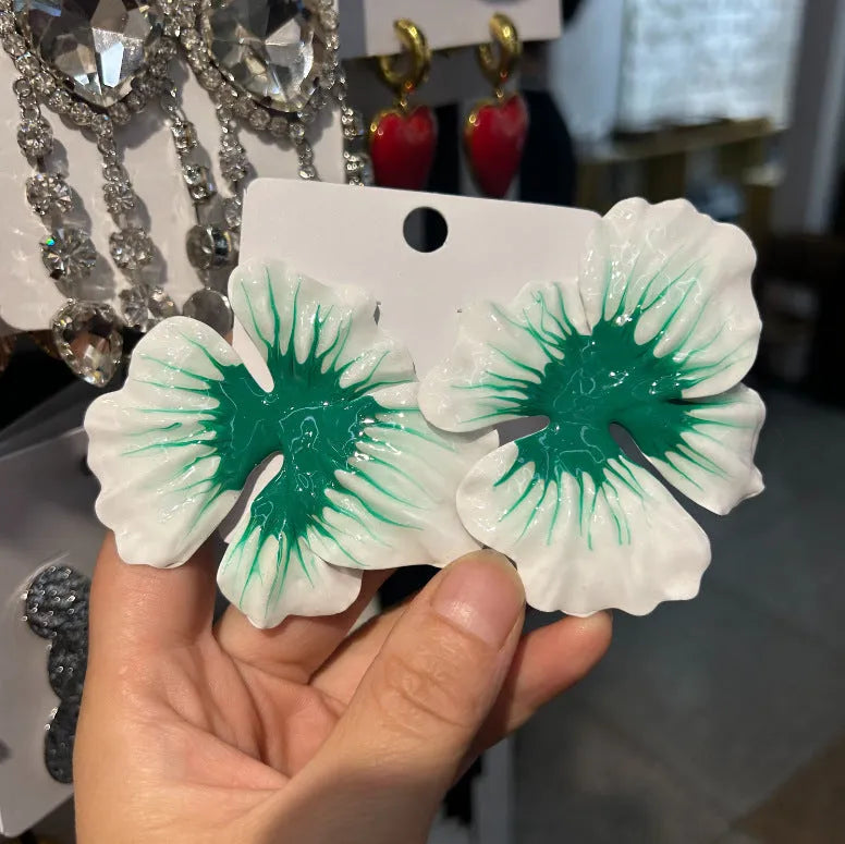 Close-up of women's alloy flower stud earrings with a blue oil-spot glaze and electroplated finish.