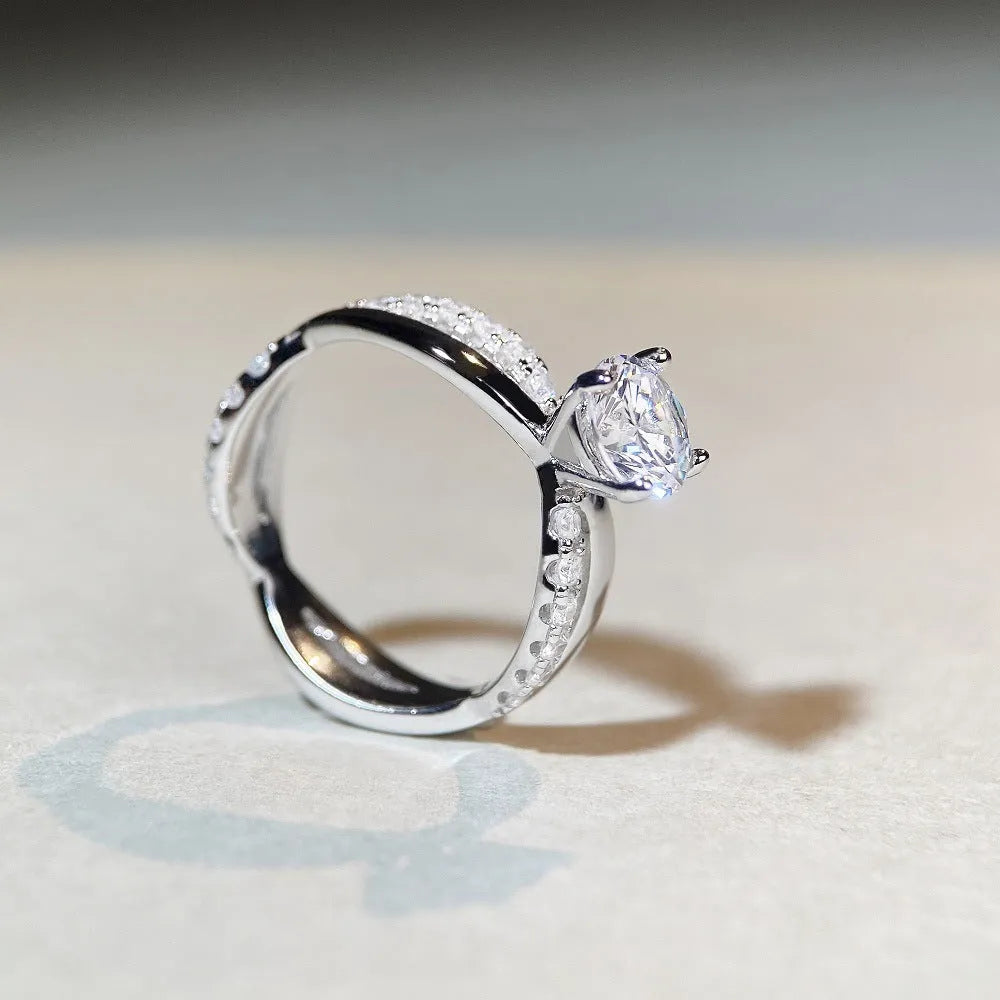 Geometric cross moissanite ring with winding twisted silver arms and four-claw setting