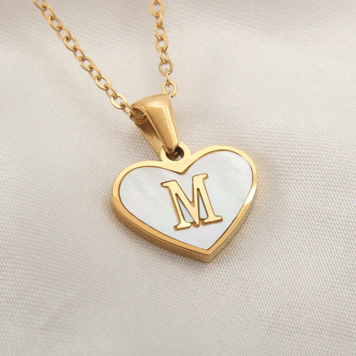 Gold plated heart-shaped necklace with white shell pendant on adjustable stainless steel chain