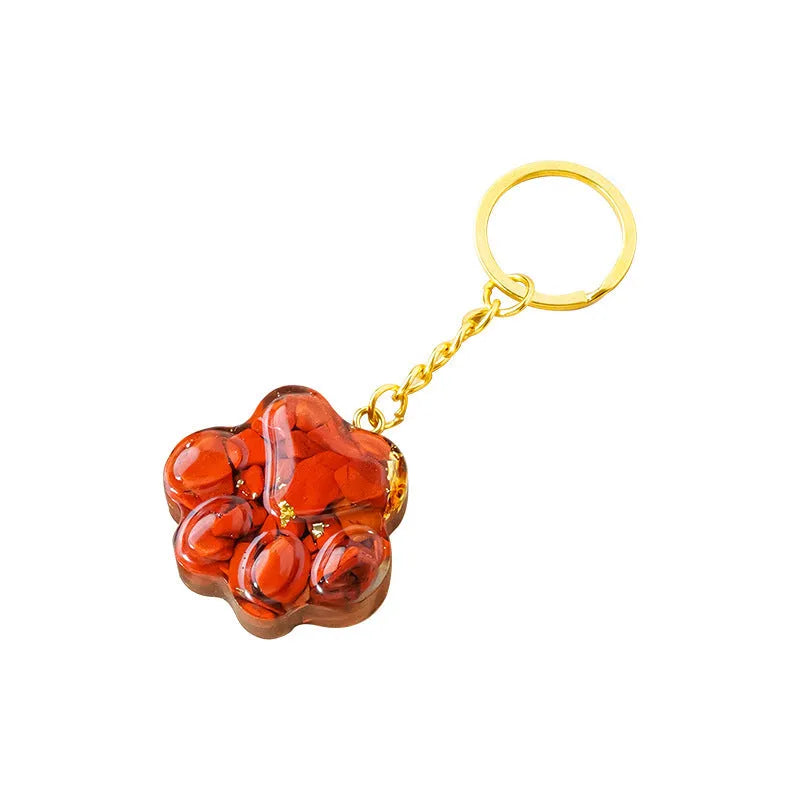 Natural crystal cat's paw shaped pendant on a silver keychain ring, shown in a random colour.