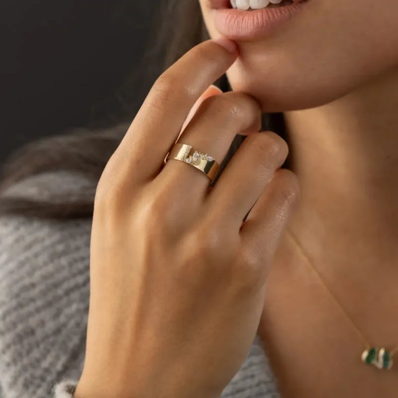 Gold electroplated zircon ring on finger showing shining finish and decorative detail