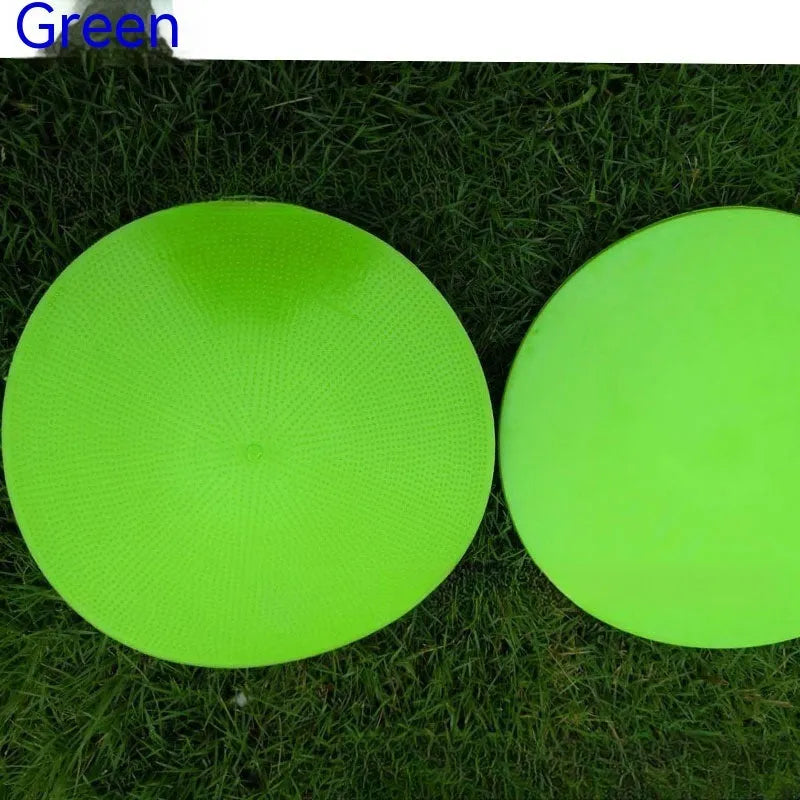 Flat, round yellow football training target disc with 23cm diameter on grass.