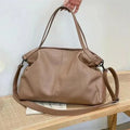 Large soft surface black messenger bag with a shoulder strap and zipper opening.