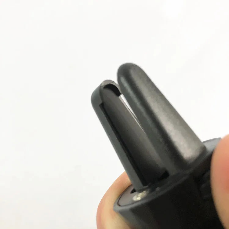 A matte black universal car phone holder mounted on a car air vent, showing the adjustable arm and phone grip.