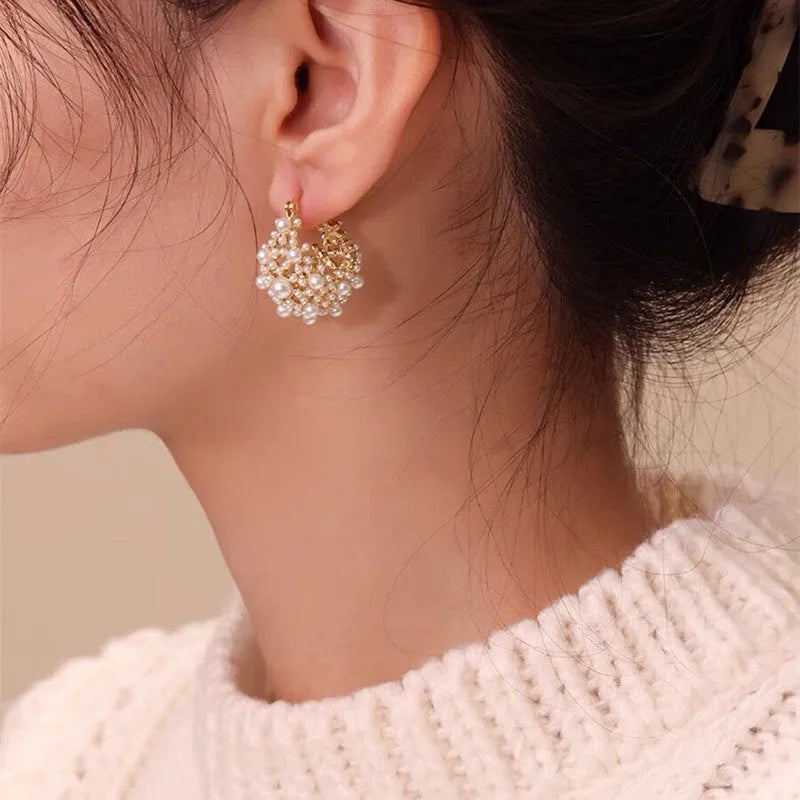 Gold copper flower basket earrings with small rice-shaped bead decoration and pearl inlay.