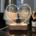 Custom transparent acrylic night light engraved with names, lit by LED base, dimensions 20cm by 11.5cm.