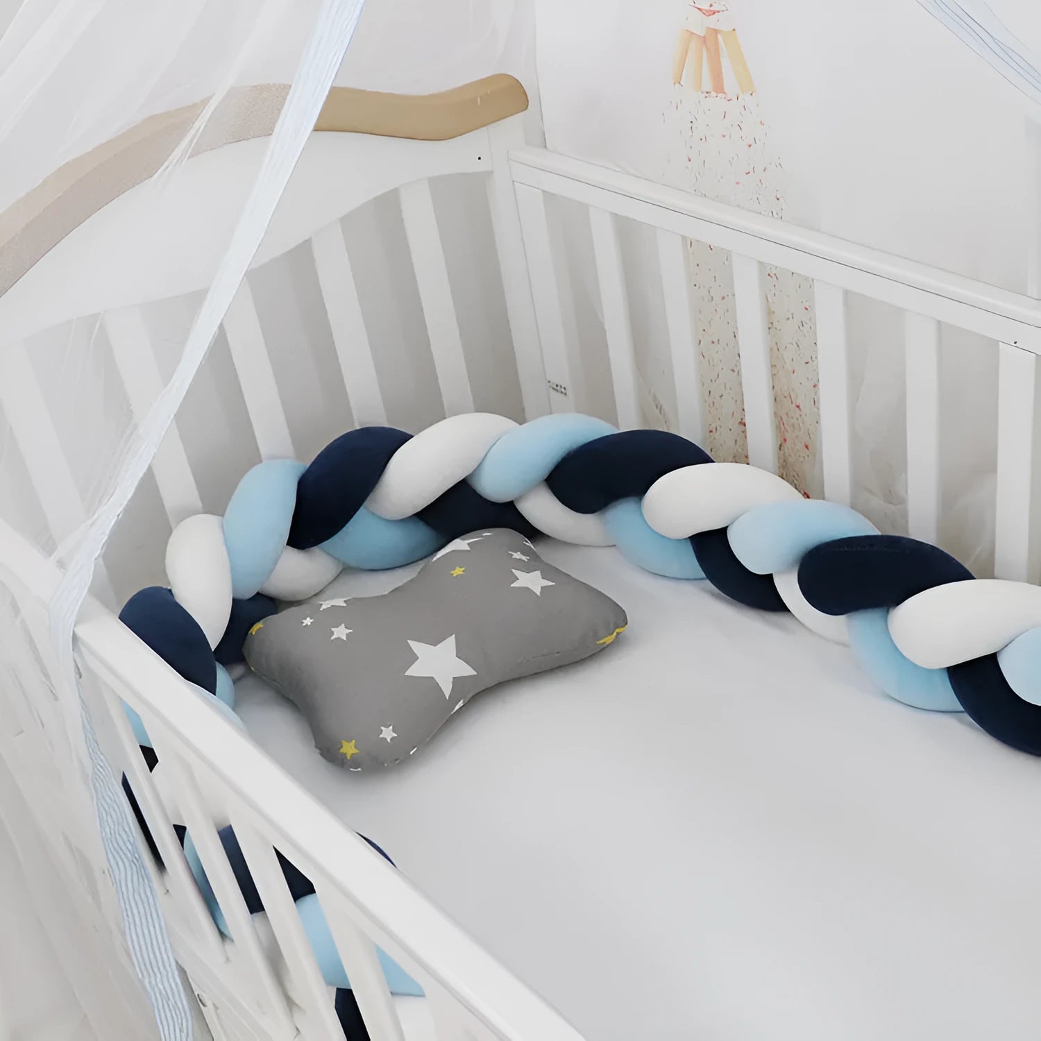 Bendable braid-knot baby crib bumper in spandex velvet, shown in a light grey colour wrapped around a cot.