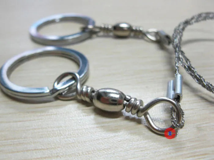 Stainless steel survival wire saw with thumb rings, total length 70cm for outdoor cutting tasks.