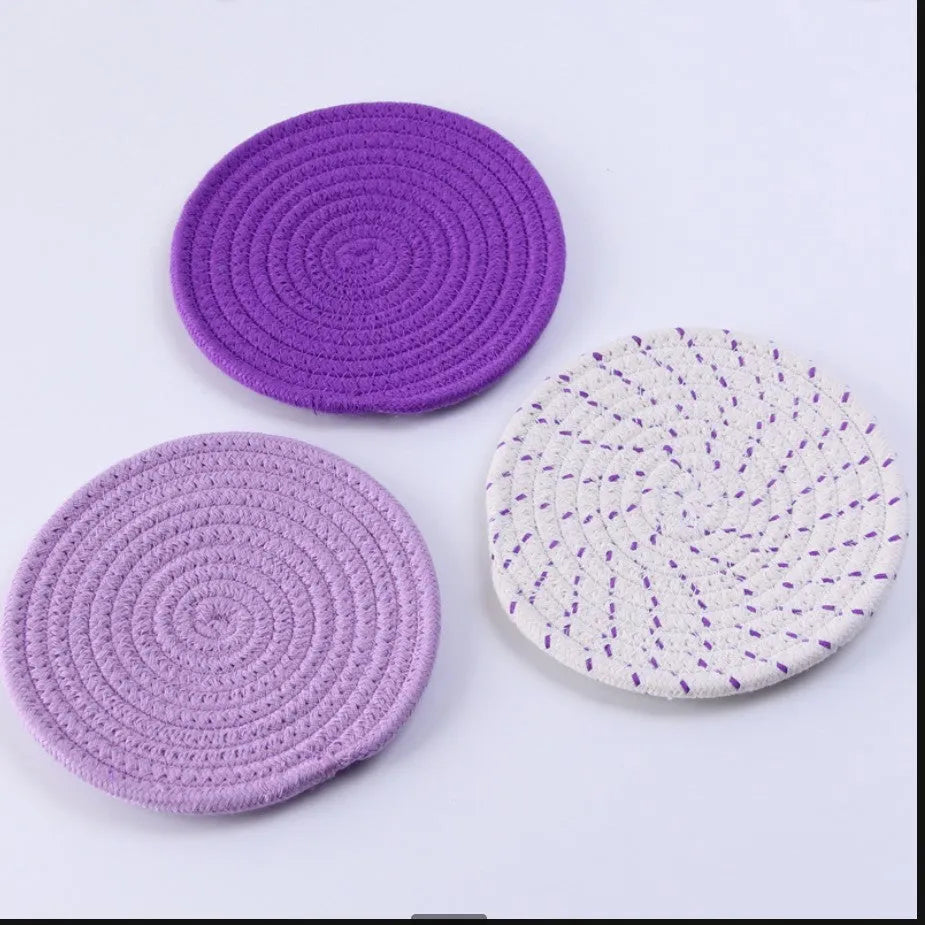 Set of three round grey cotton cord coasters on a wooden table, each 18cm in diameter.