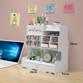 Square plastic pen holder storage box with multiple oblique insertion compartments on a desk.