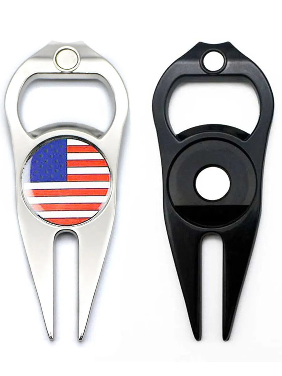 Black zinc alloy golf ball fork and bottle opener tool on green turf