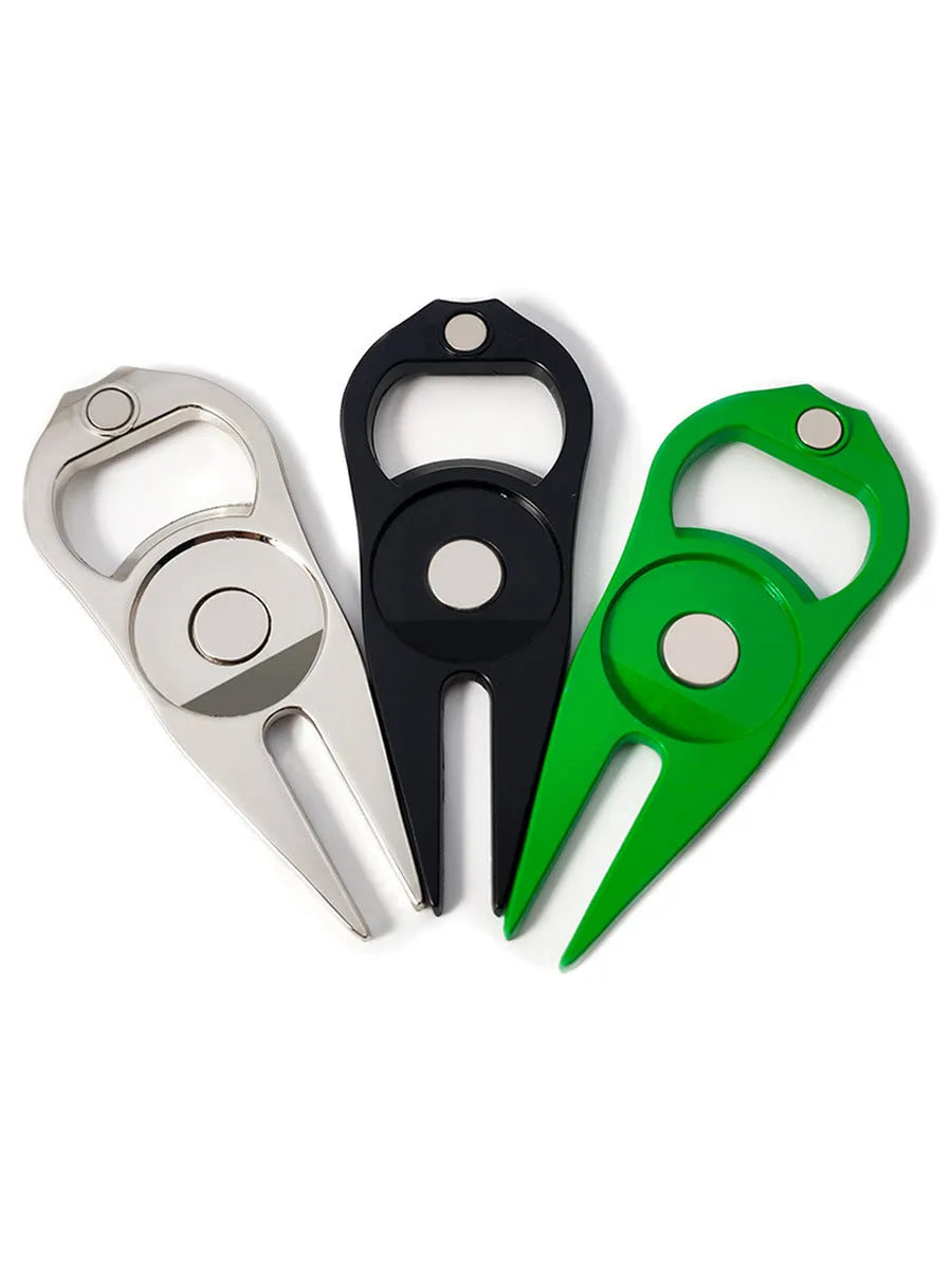Black zinc alloy golf ball fork and bottle opener tool on green turf