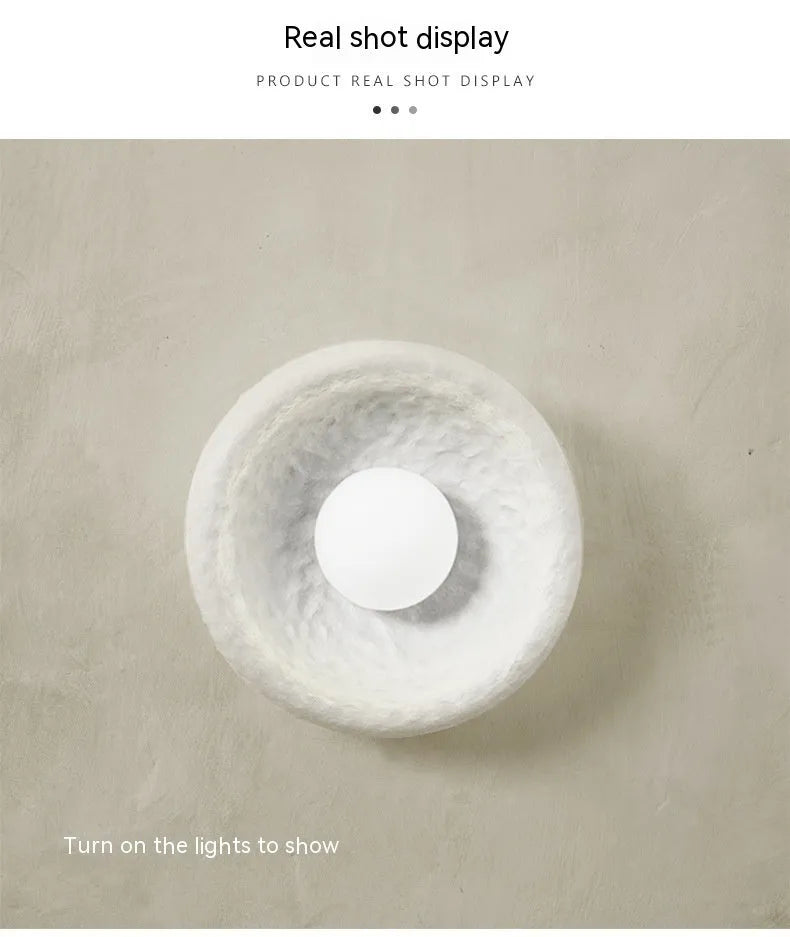 Japanese-style wall lamp with resin shade in three diameter sizes on white wall