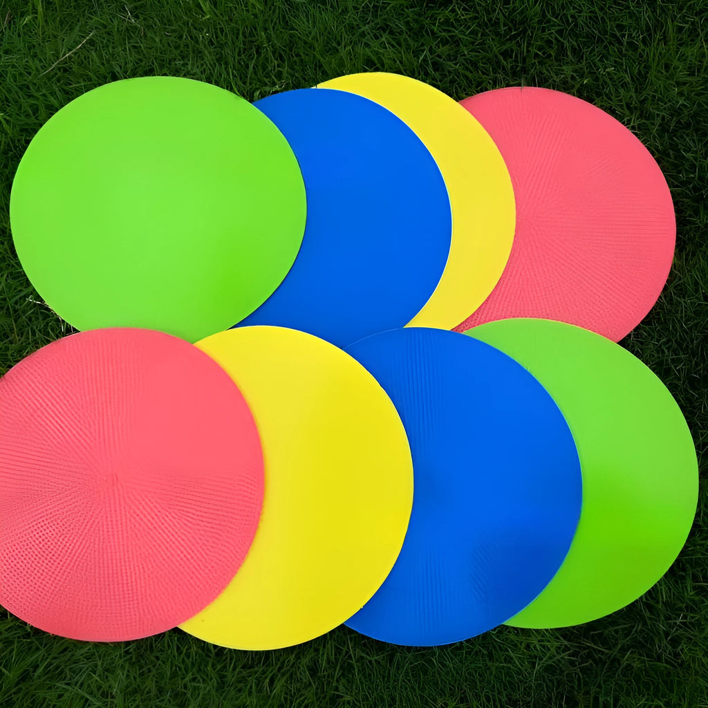 Flat, round yellow football training target disc with 23cm diameter on grass.