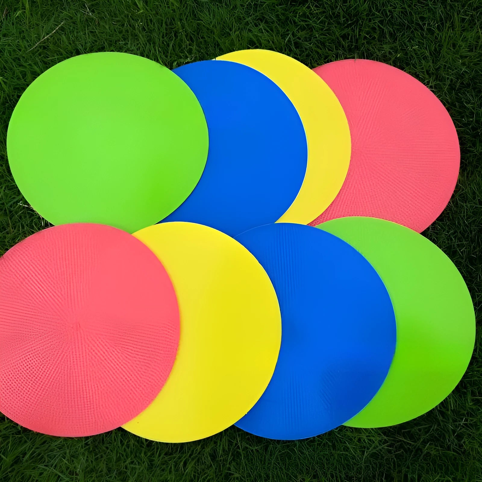 Flat, round yellow football training target disc with 23cm diameter on grass.