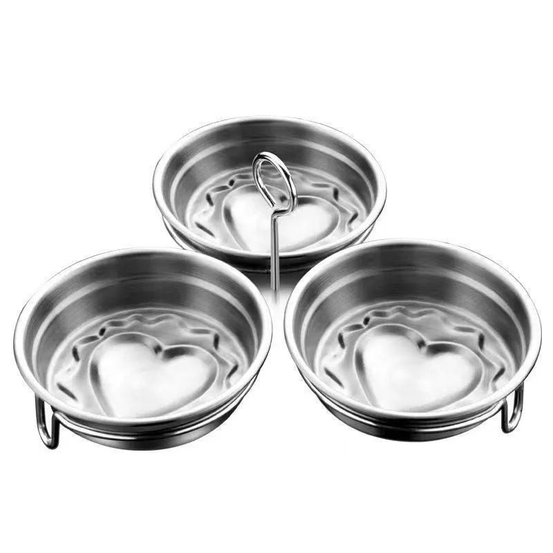 Compact stainless steel heart-shaped electric egg steamer on a kitchen counter.