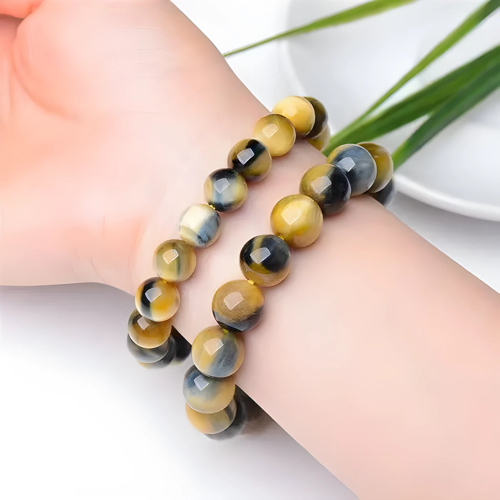 Fantasy tiger eye agate stone bracelet with round beads in geometric pattern on wrist.