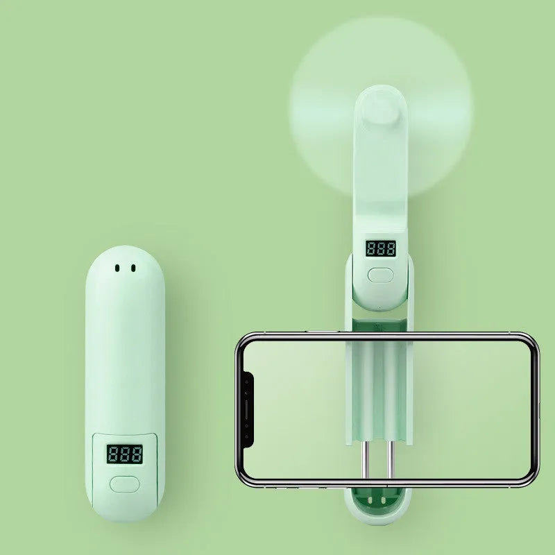 Green folding USB mini fan with plastic leaves on a white background