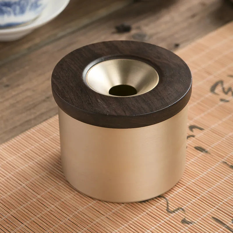 Brass ashtray with wooden lid in copper construction showing centre hole design