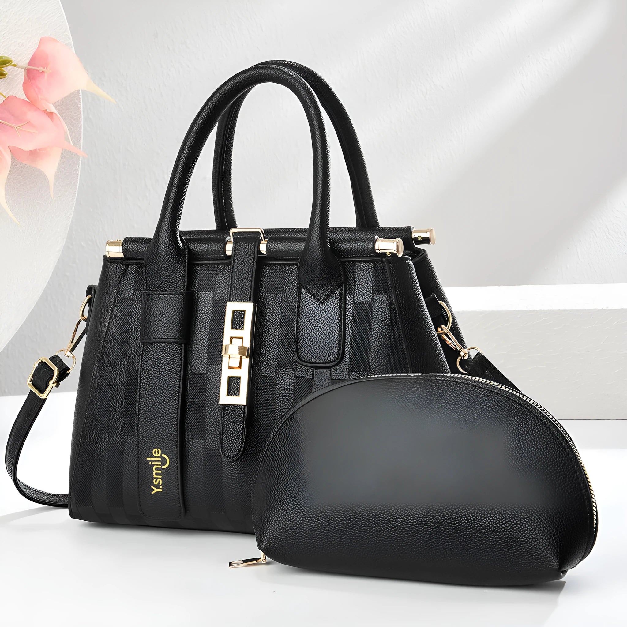 A pair of round black and light khaki PU leather crossbody bags with adjustable straps.