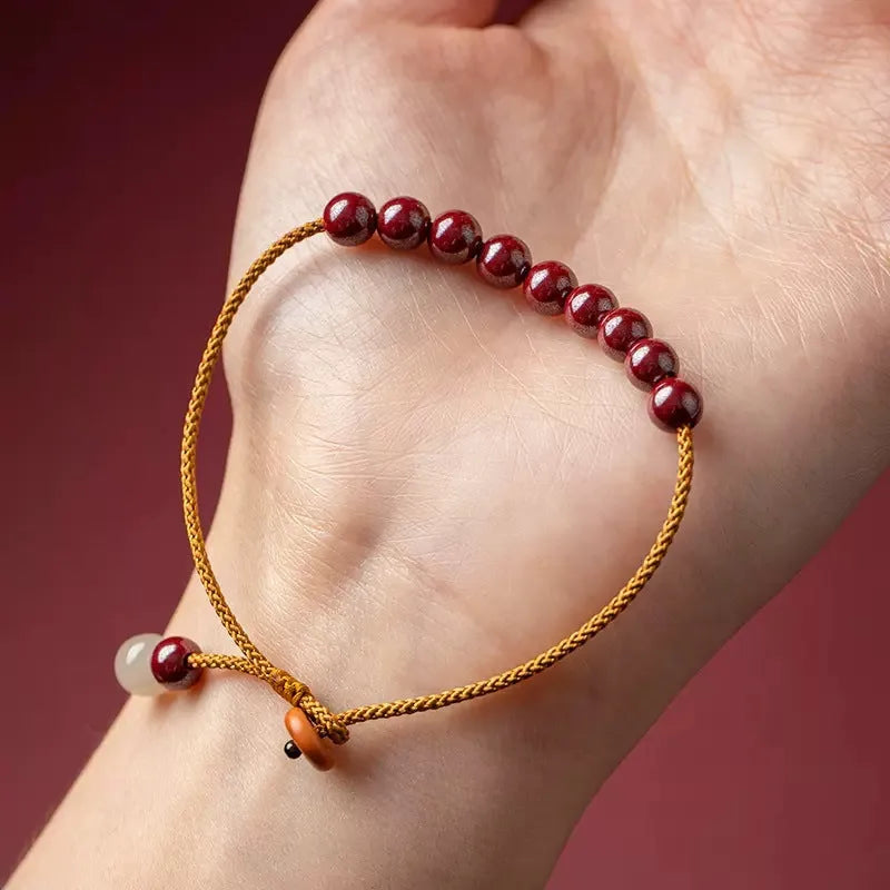 Hand-woven cinnabar geometric bracelet showing raw ore material texture and adjustable design