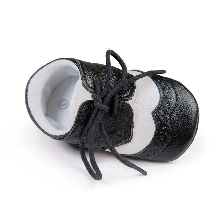 Vintage baby shoes with soft soles in light brown colour showing synthetic leather upper