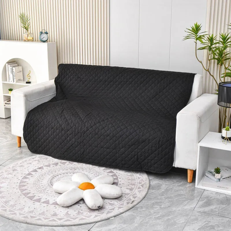 Reversible waterproof dog blanket laid flat on a sofa, showing two colour options.