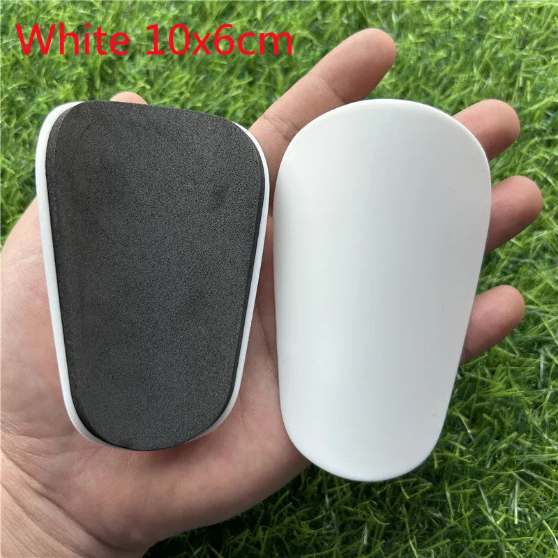 Pair of extra small black and white plastic football shin guards measuring 8x5cm for youth players