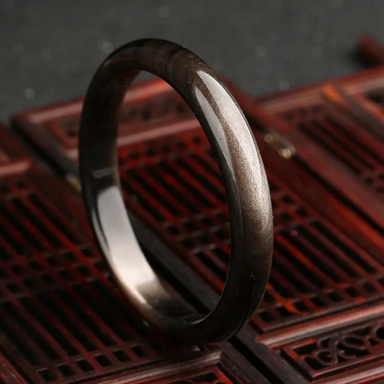 Natural silver stone cat's eye ethnic geometric bracelet made from crystal and alloy on a wrist.