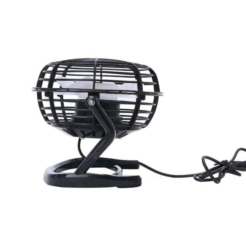 Black mini USB desk fan with adjustable head on a wooden desk next to a laptop.