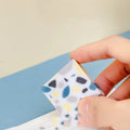 White brick-shaped rubber eraser on a surface, a stationery tool for pencil mark removal.