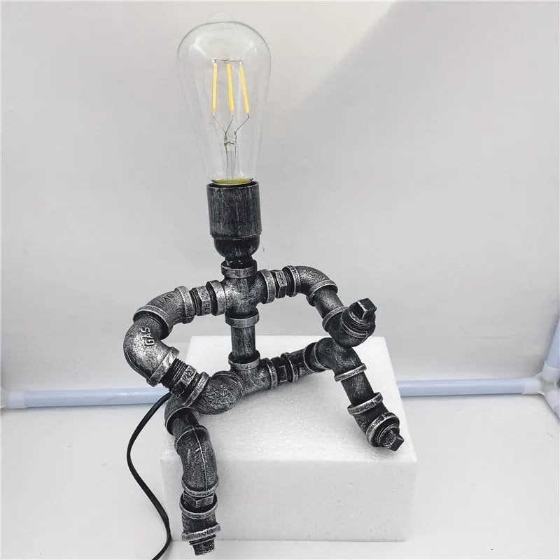 Iron pipe industrial retro style table lamp in vintage colour on a wooden desk.