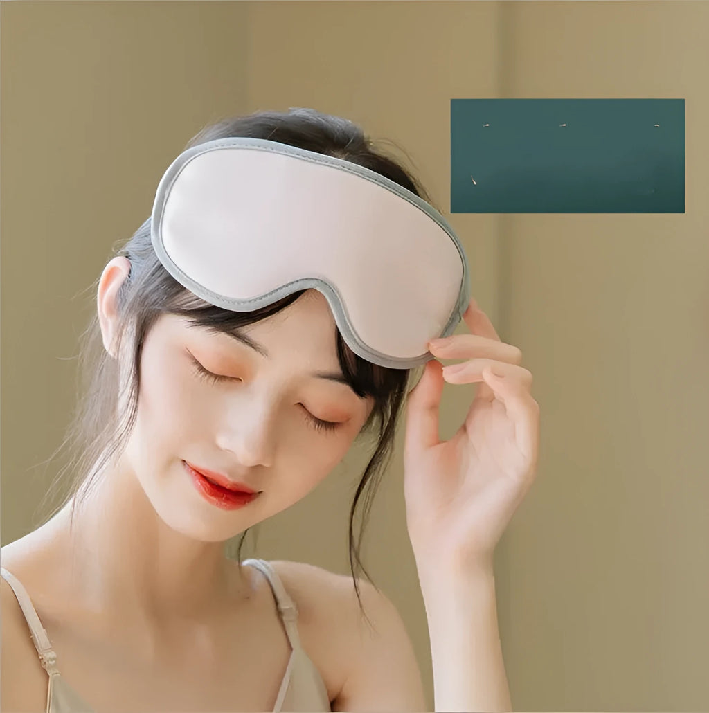 Pink and green portable eye SPA massage goggles with suede shell on a grey background.