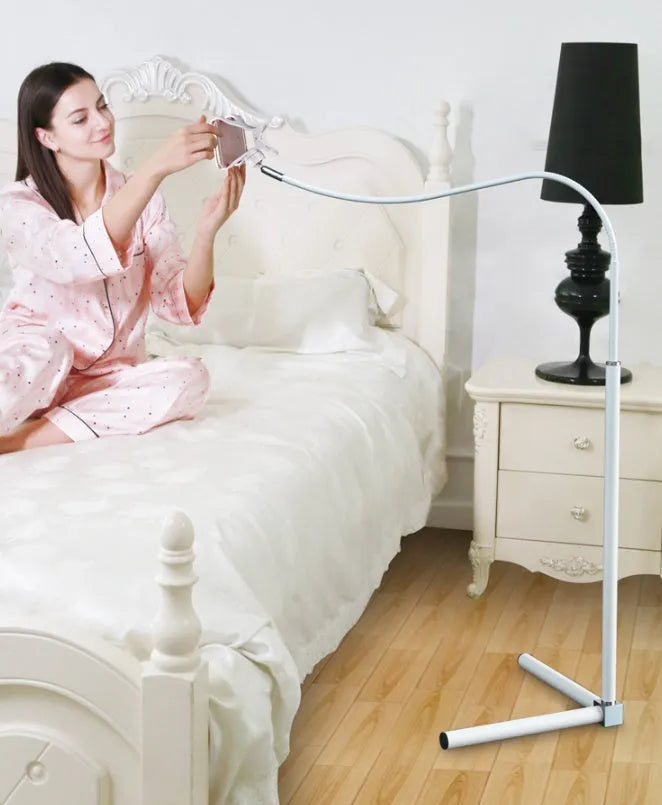 Black bedside phone holder with universal mobile phone bracket and adjustable overhead support shelf positioned next to bed